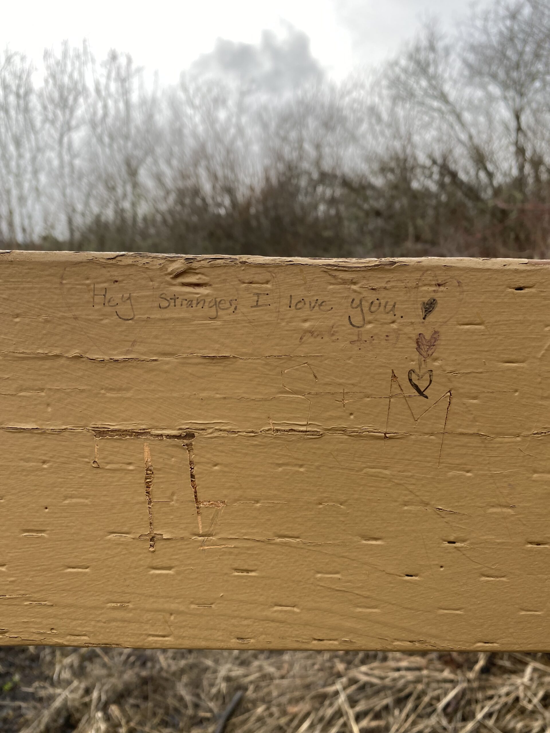 Graffiti on the dock reads "Hey stranger, I love you." Beneath it reads "me too."